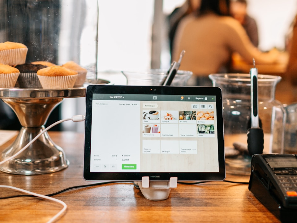 Tablet point-of-sale system on a restaurant counter showing the POS interface